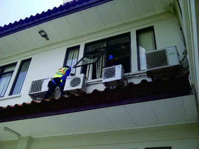 Teknisi memasang AC split di lantai dua gedung di Klaten