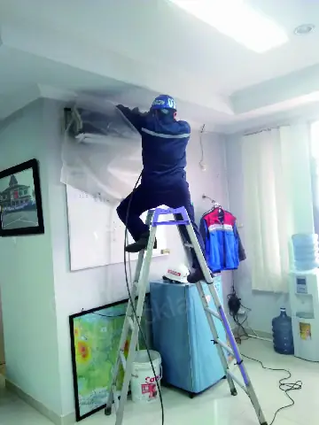 Cuci AC indoor dengan plastik penampung air agar ruangan tetap bersih